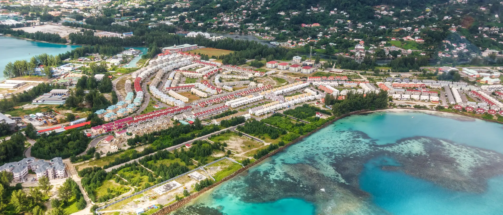 Aerial photo of neighbourhood, coastline and mountains in the background