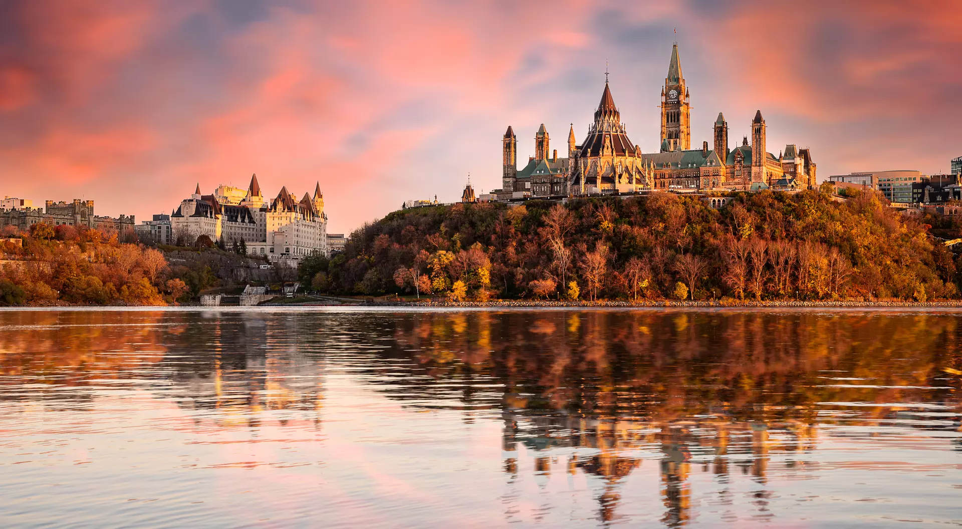 Parliament Hill and the Chateau Laurier alongside the Ottawa River at sunset