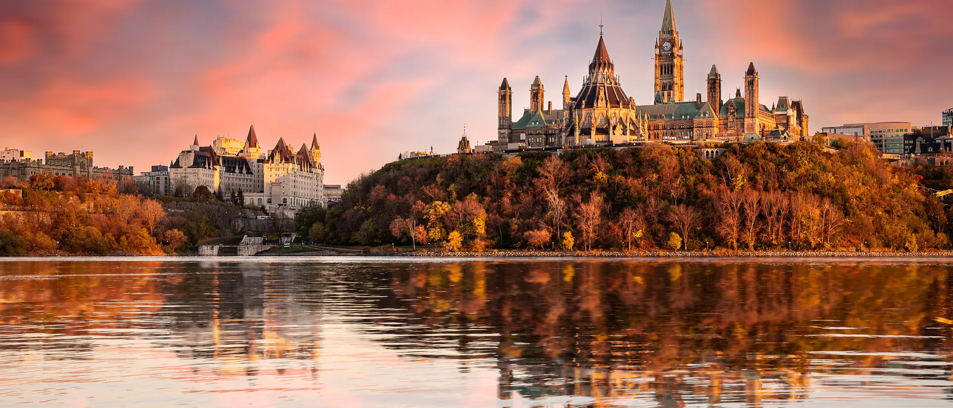Parliament Hill and the Chateau Laurier alongside the Ottawa River at sunset