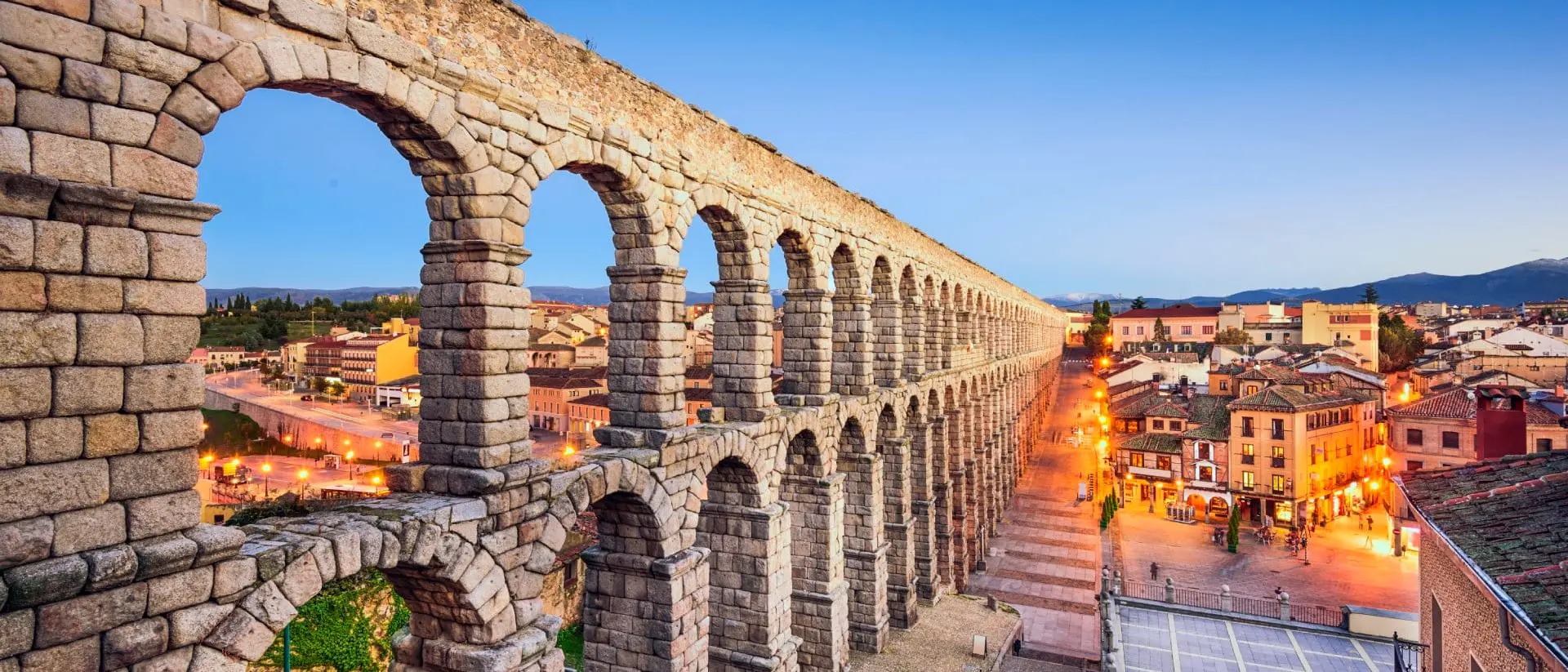 Roman Acqueduct, Segovia, Castille y Leon Ancient Roman aqueduct cutting through ancient village at twilight.