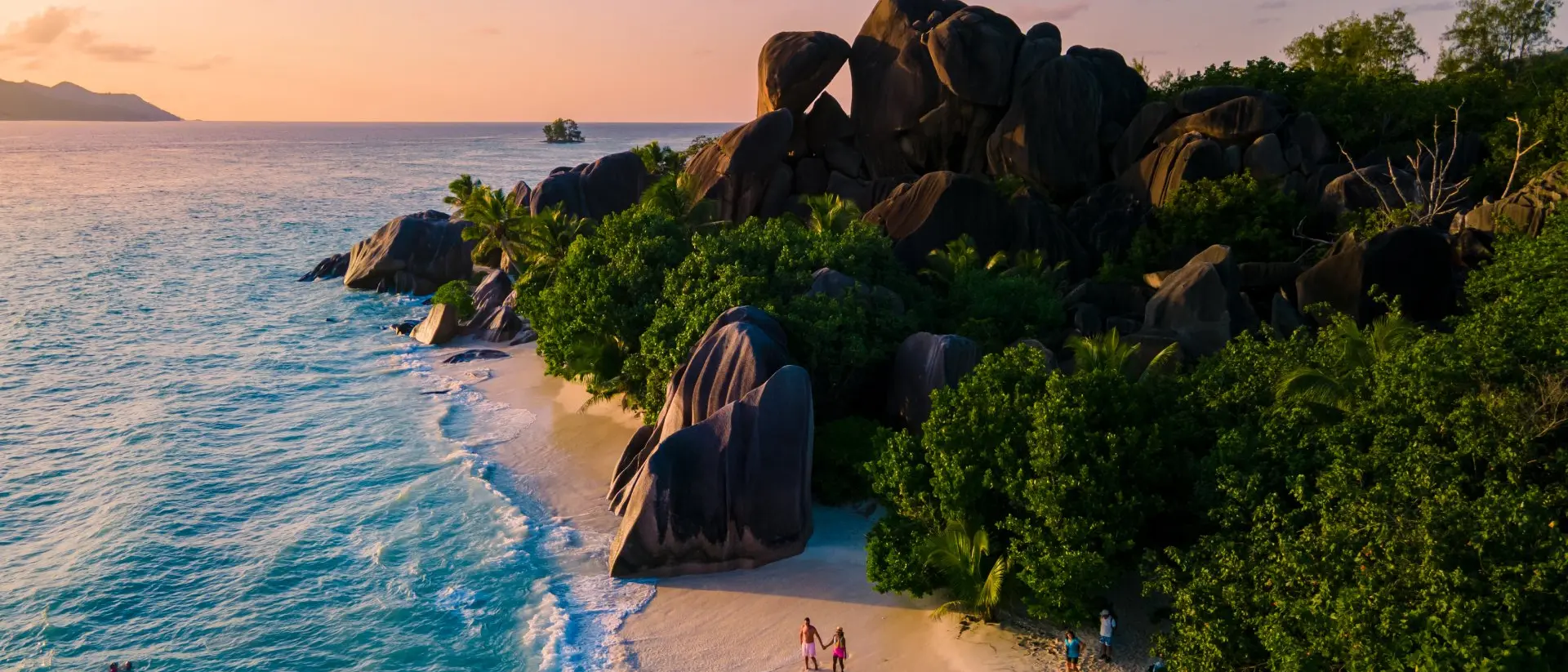 Seychelles Anse Source d'Argent, La Digue Seychelles, young couple men and woman on a tropical beach during a luxury vacation in the Seychelles.