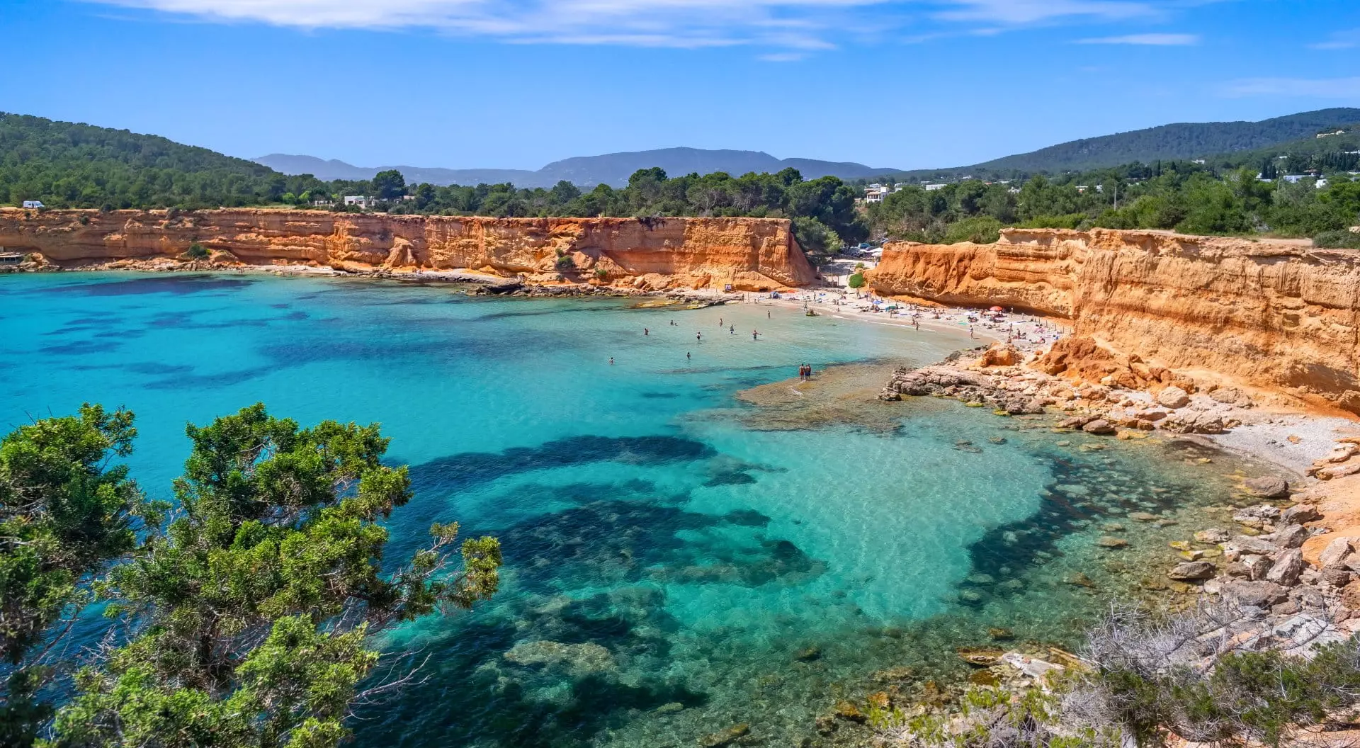 Bright light of a summer noon, transparent waters marbled with Posidonia meadows, sparse bathers on the beach.