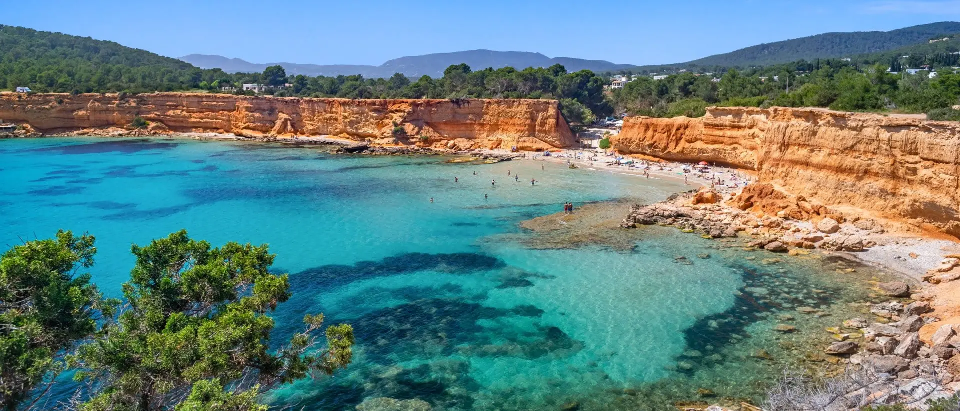 Bright light of a summer noon, transparent waters marbled with Posidonia meadows, sparse bathers on the beach.