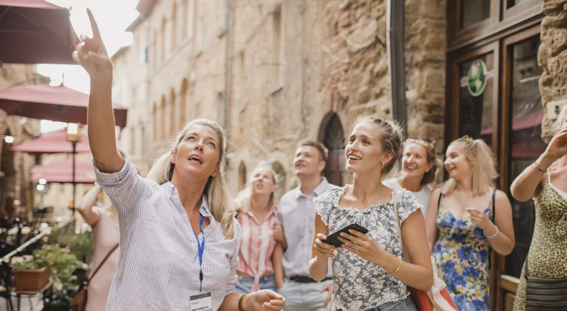 Group of people standing in a street in Volterra learning about architecture and the history
