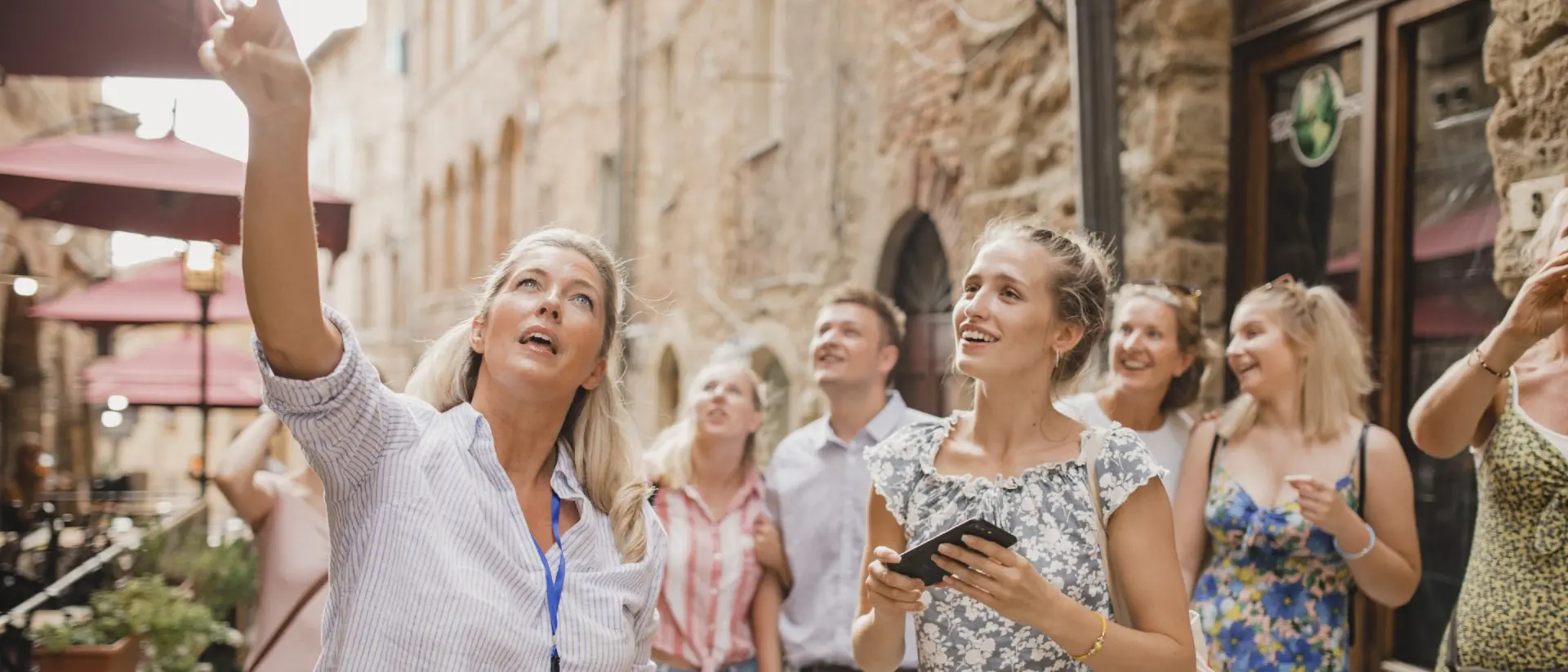 Group of people standing in a street in Volterra learning about architecture and the history