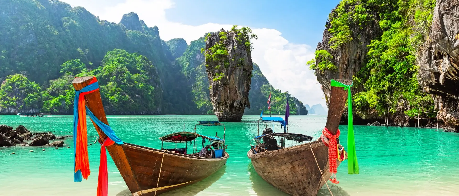 James Bond island with thai traditional wooden longtail boat and beautiful sand beach in Phang Nga bay, Thailand