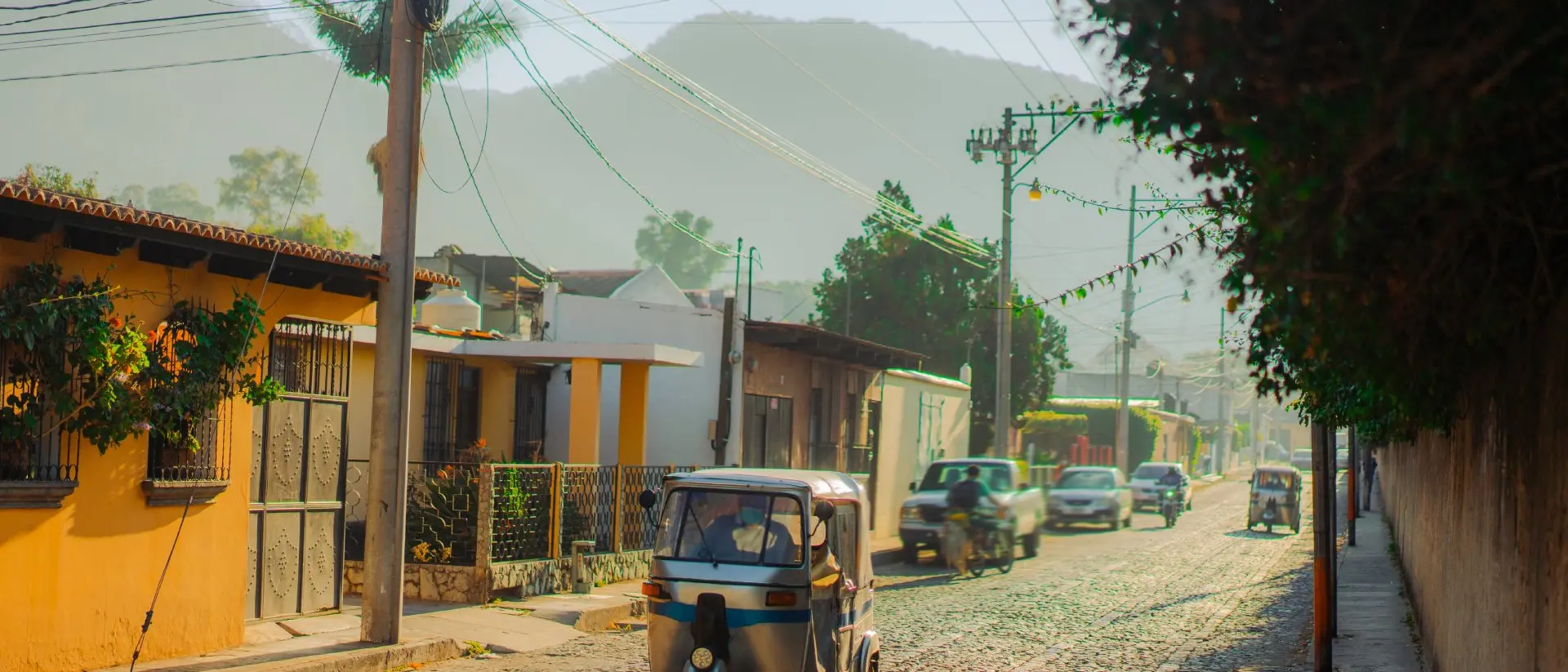 Tuk-tuk three wheeled vehicle driving along historical street in Guatemala