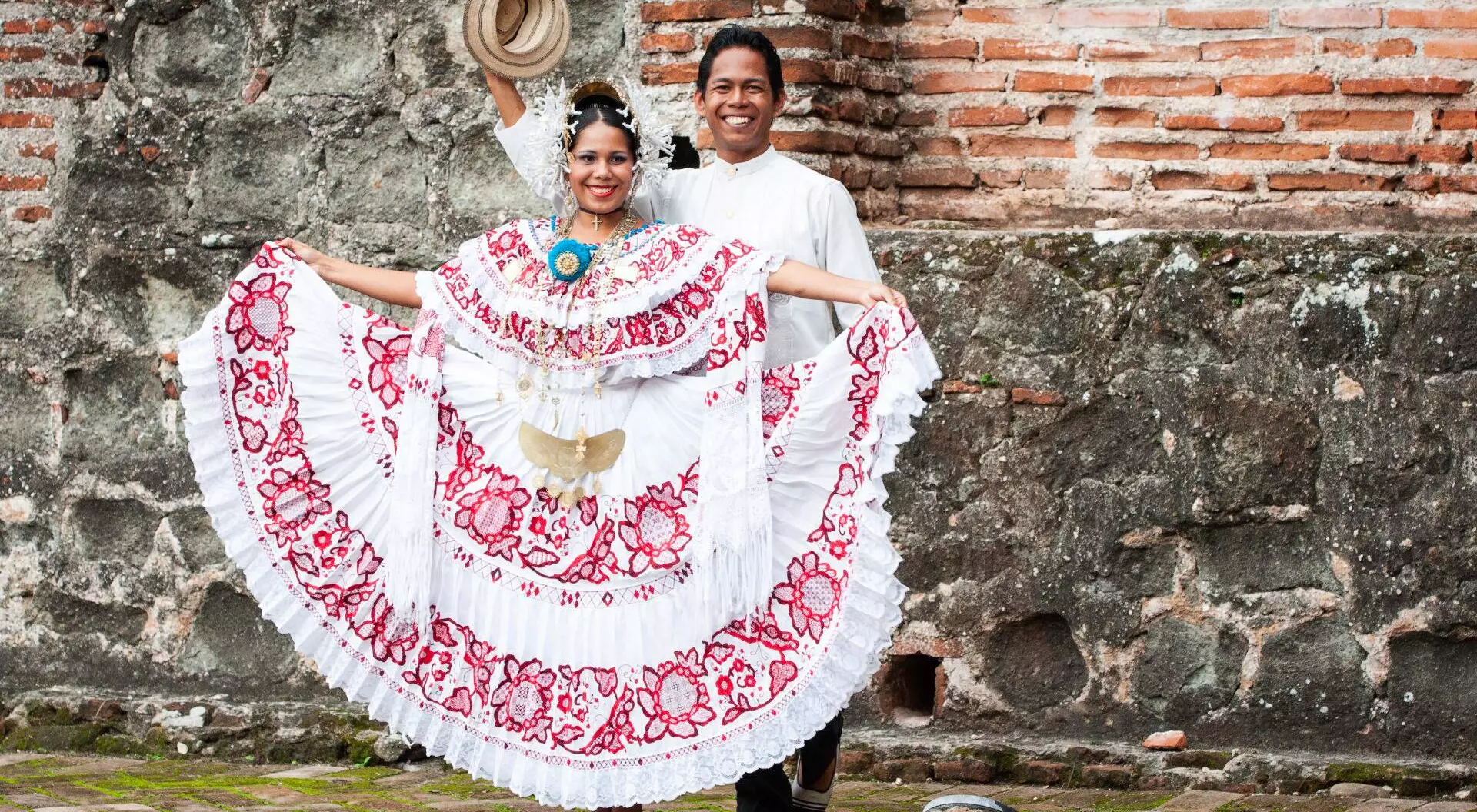Woman wearing a pollera Panama's national costume, and man wearing a traditional tunic mole at Panama la Vieja ruins, Panama City, Panama