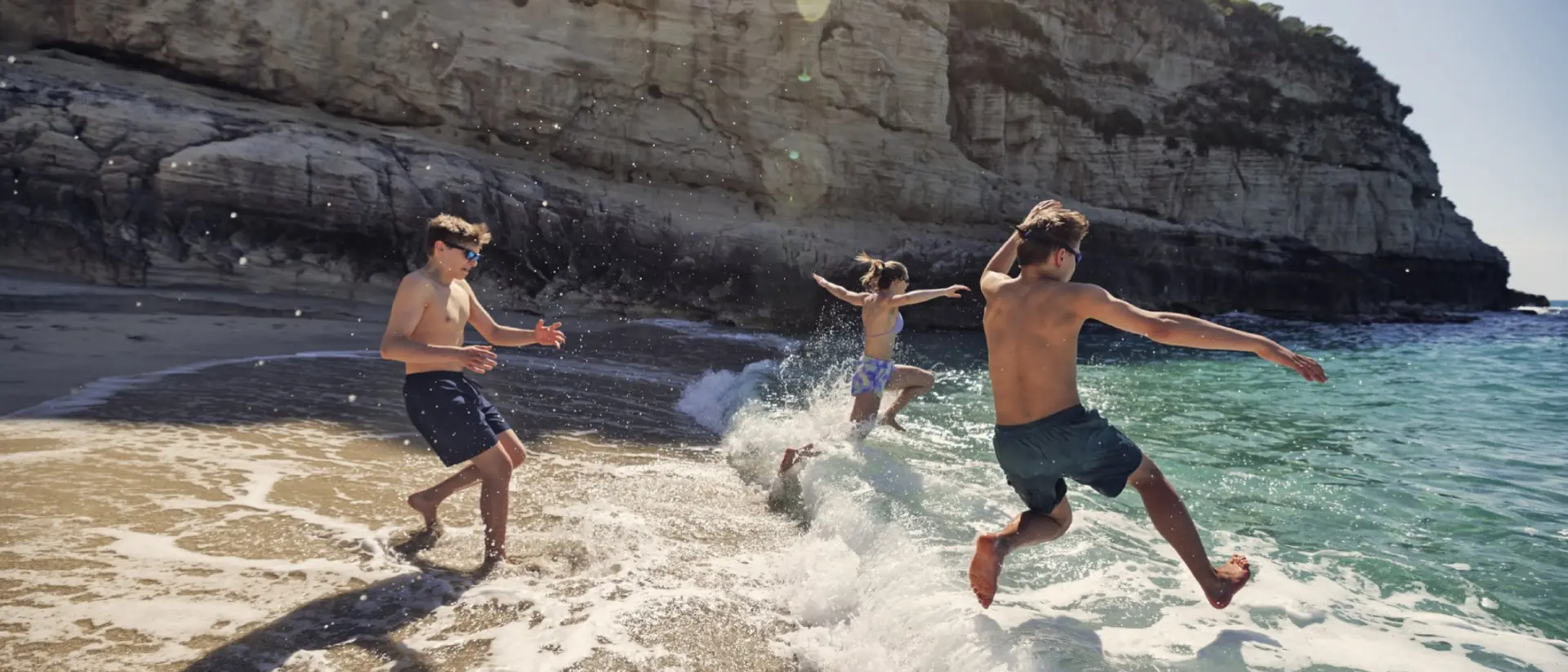 Catania, Italy A bunch of happy teenagers running into the surf in Italy
