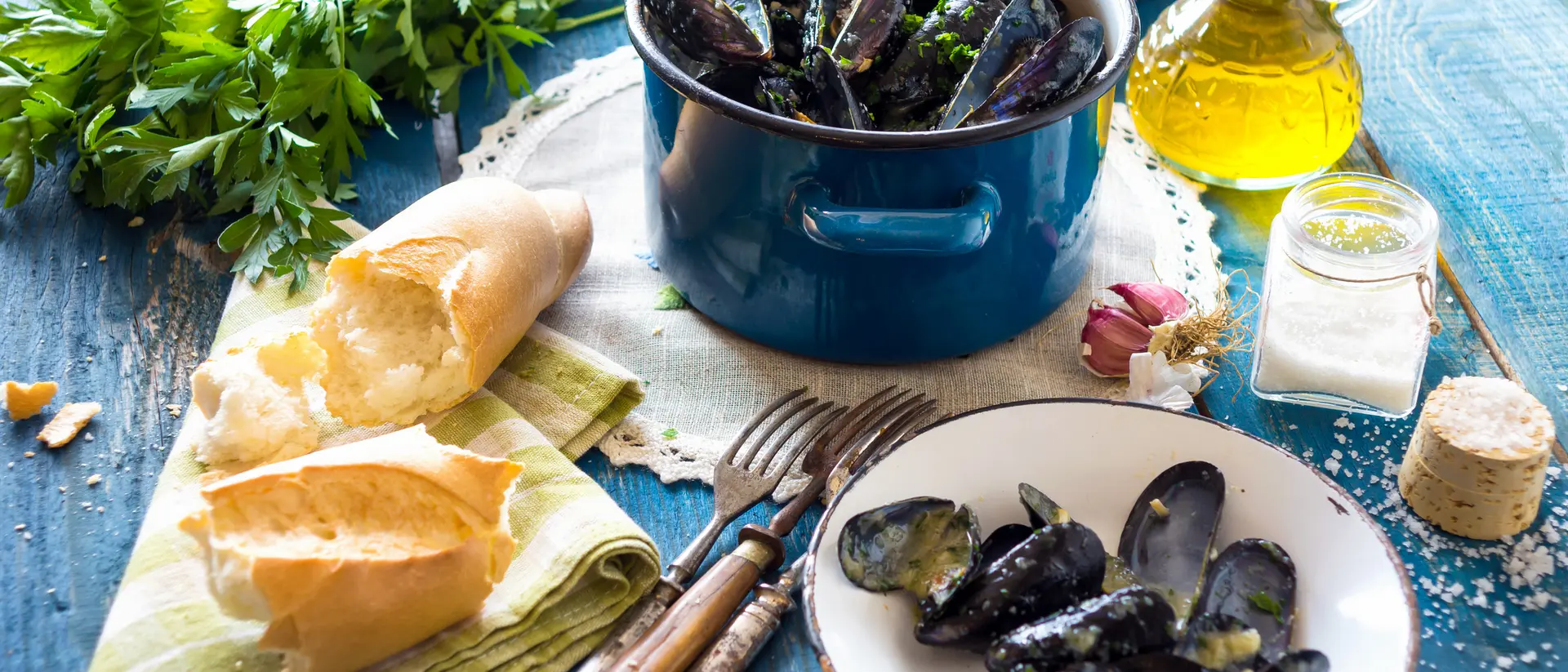 Mussels in Buzara sauce on a table with olive oil and bread