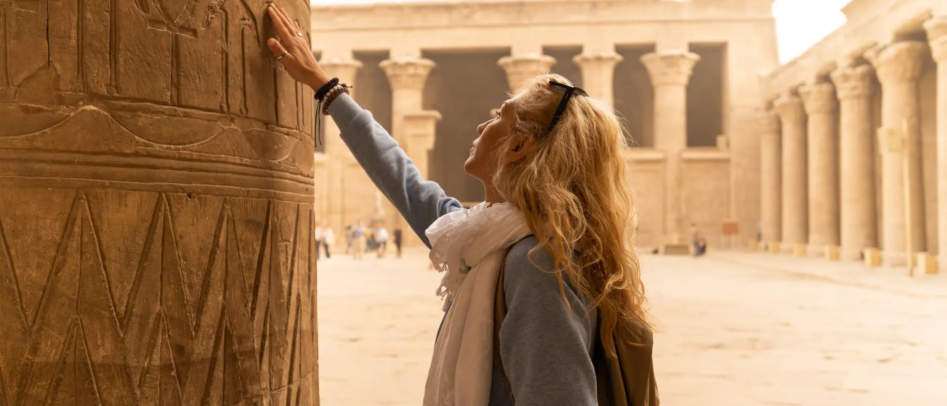 Temple of Horus, Edfu Female tourist touching columns of the temple of Horus in Edfu, Egypt. Esna and Aswan in Egypt.