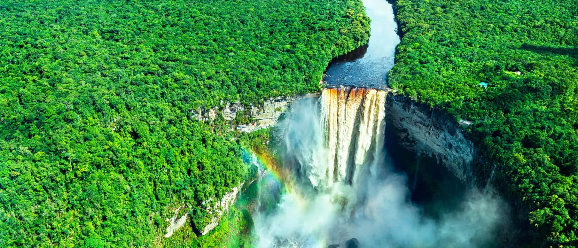 Aerial view of Kaieteur Falls with a rainbow in a rainforest in Guyan