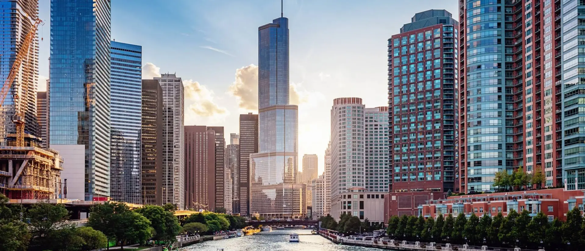 Chicago, United States Cityscape from Chicago River Waterfront at Dusk. Small boats and tourist ferries cruising towards the Michigan Lake