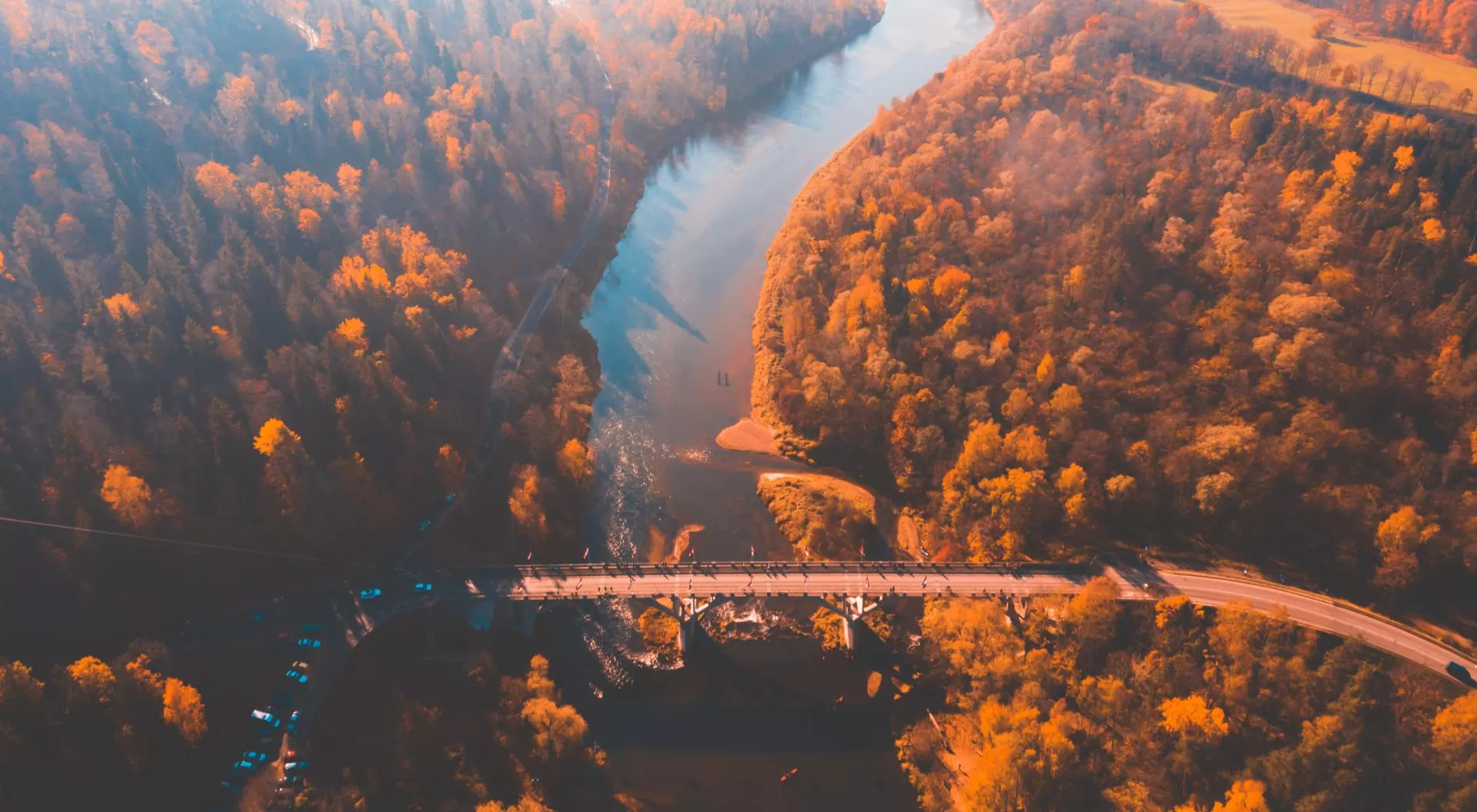 Aerial morning view of the golden autumn in Sigulda, Latvia. Gauja river bridge, cable car and golden forest.