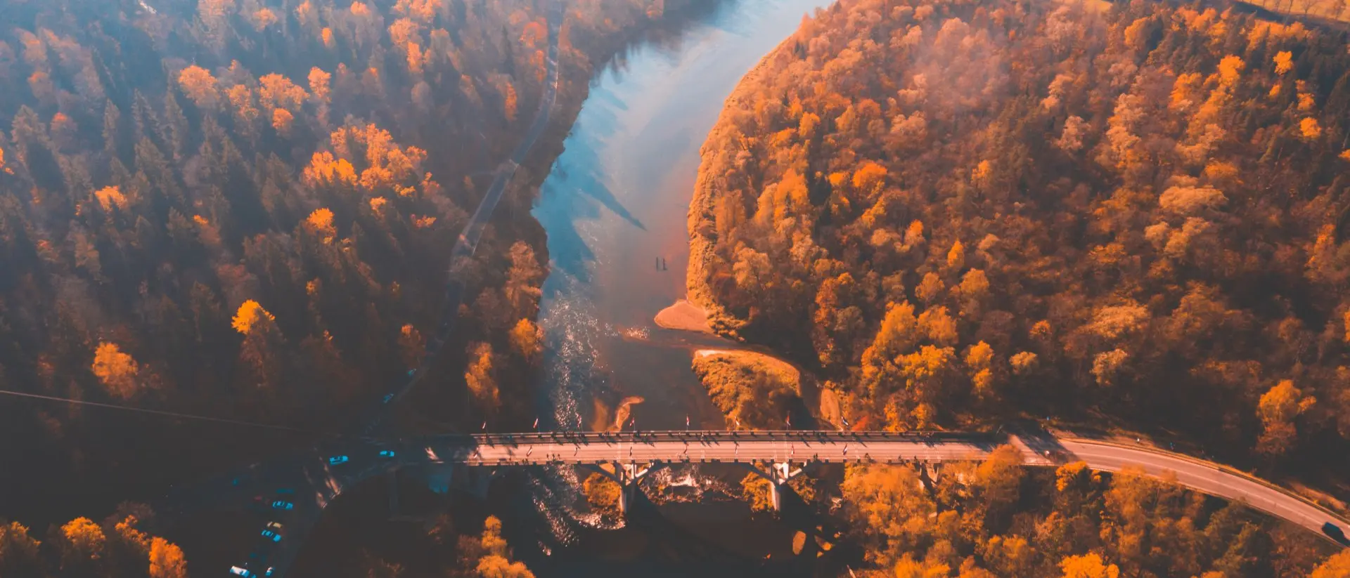 Aerial morning view of the golden autumn in Sigulda, Latvia. Gauja river bridge, cable car and golden forest.