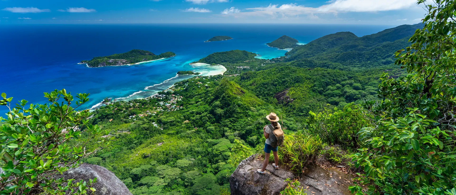 Mountains of Mahe Island Woman hiker standing high above indian ocean on tropical island of seychelles mahe enjoying amazing view