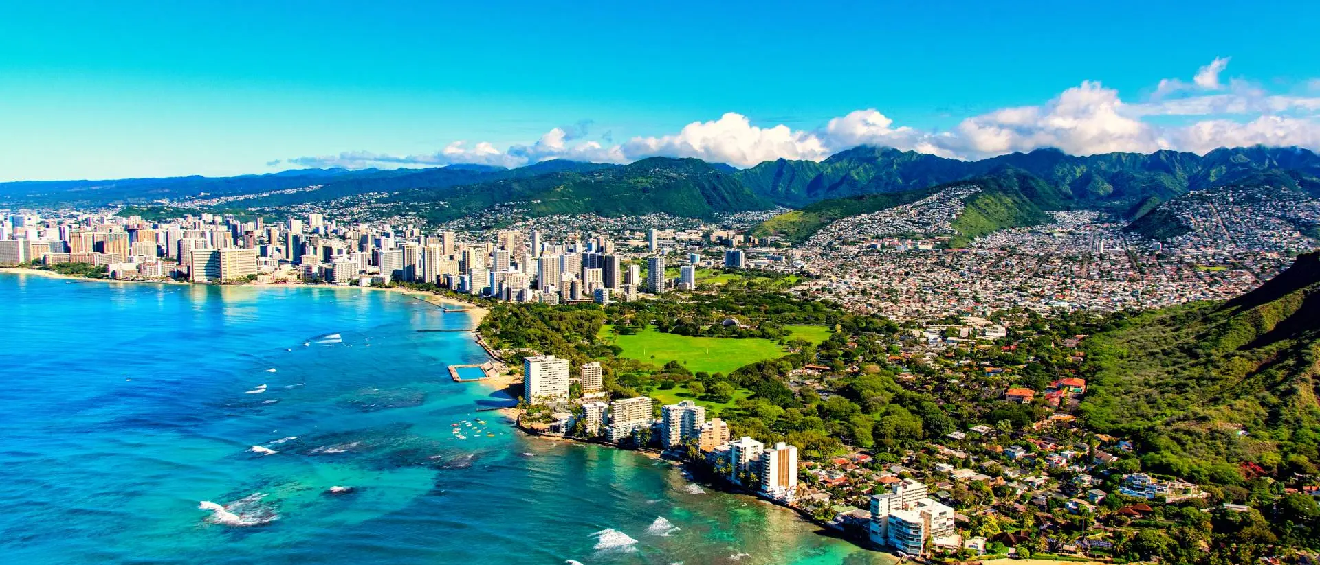 Honolulu, United States The entire coastline including the base of Diamond Head crater and state park, past the hotel lined Waikiki Beach towards downtown in the distance including the suburban neighborhoods dotting the hills surrounding the city center.