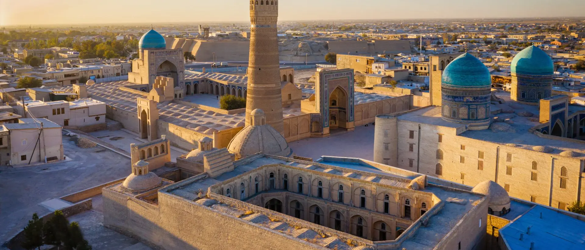 Sunset over the famous Kalyan Poi Kalon Minaret, Poi Kalan or Po-i-Kalyan and Mir Arab Madrasah in the center of the old town of Bukhara