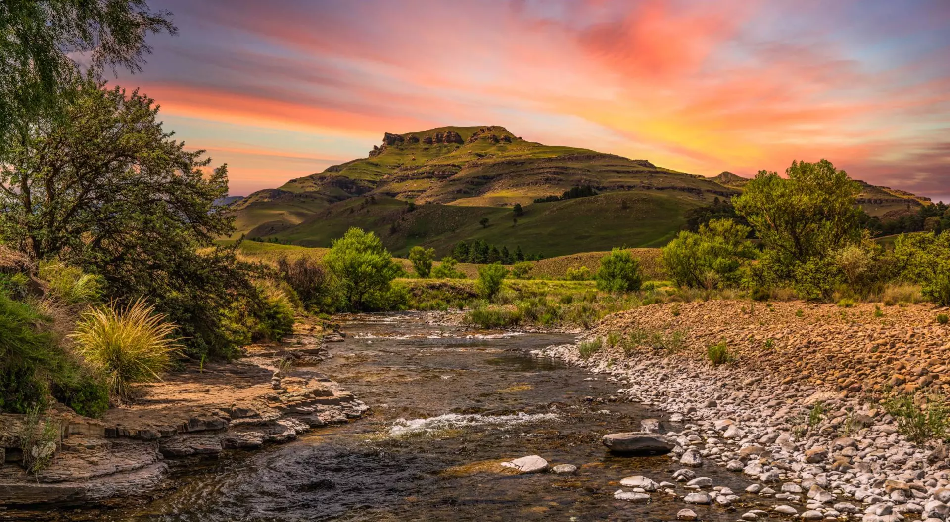 Drakensberg valley and a river running through it during sunset