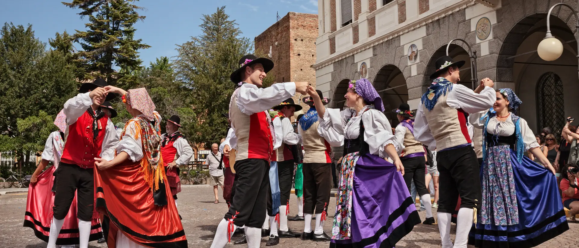 A traditional dance performance with performers in colorful costumes, set in a lively outdoor space.