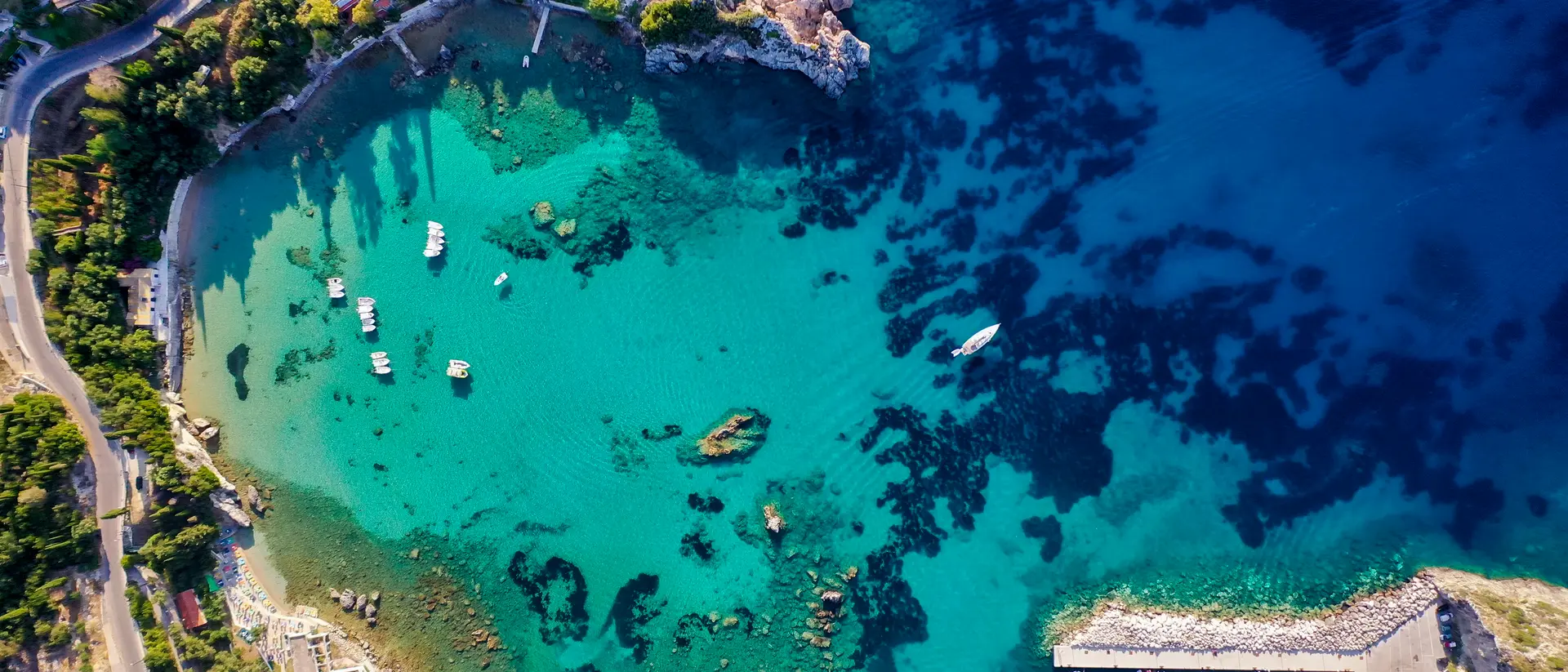 Aerial view of the beautiful Corfu coastline, showing deep blue colours of the Mediterranean Sea