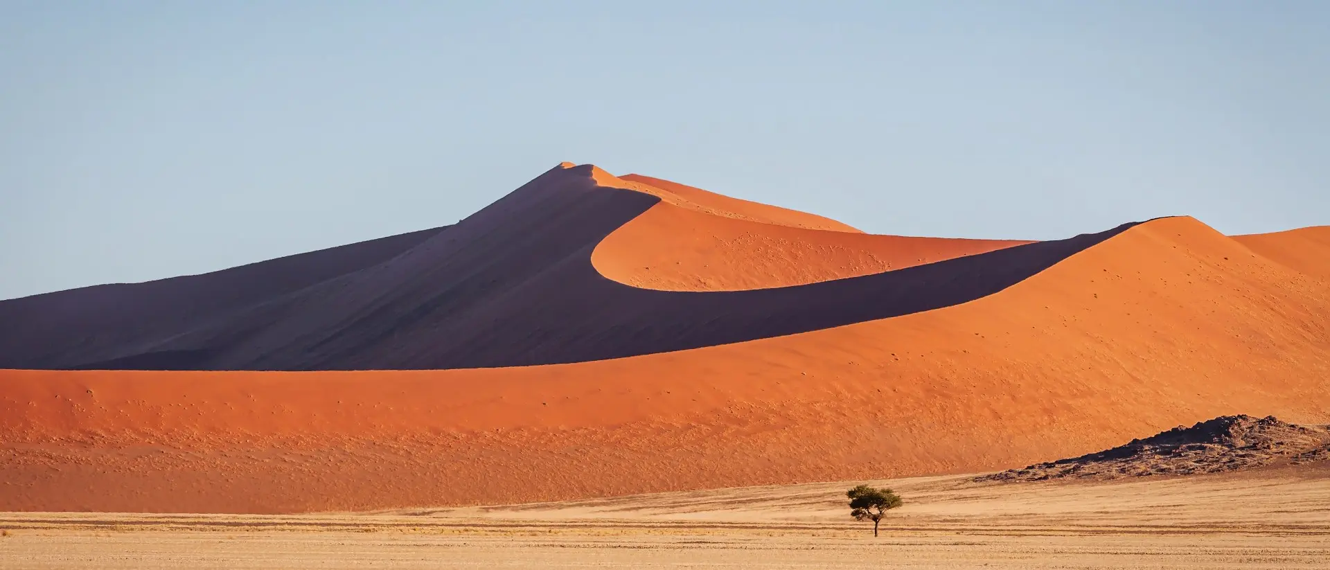 Warm late afternoon light close to sunset shining over the majestic Namibian Desert Sand Dunes