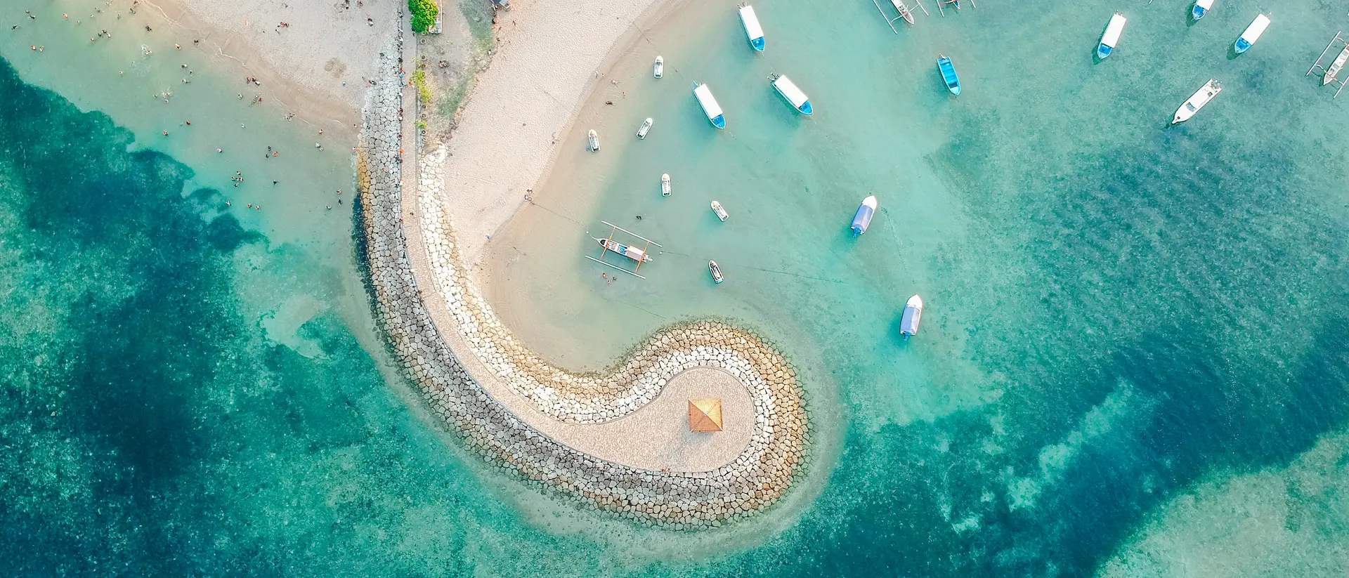 Sanur Beach Aerial drone view of ocean, traditional Balinese boats, beach, shore on Sanur Beach, Bali
