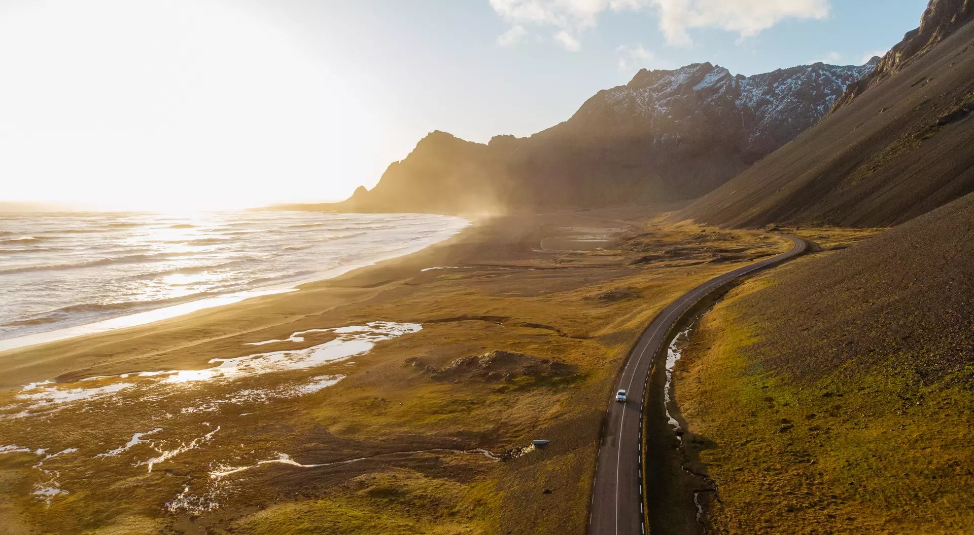 Uncover the magic of Iceland on your next road trip. Aerial view of a car driving on scenic road in Iceland