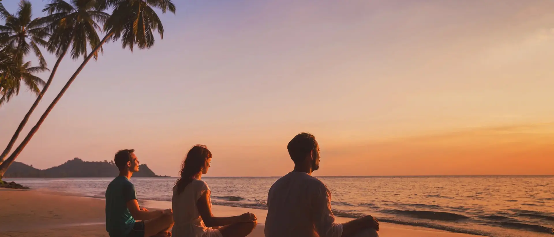 Three people meditating on a beach at sunset, with palm trees and calm ocean waves in the background.