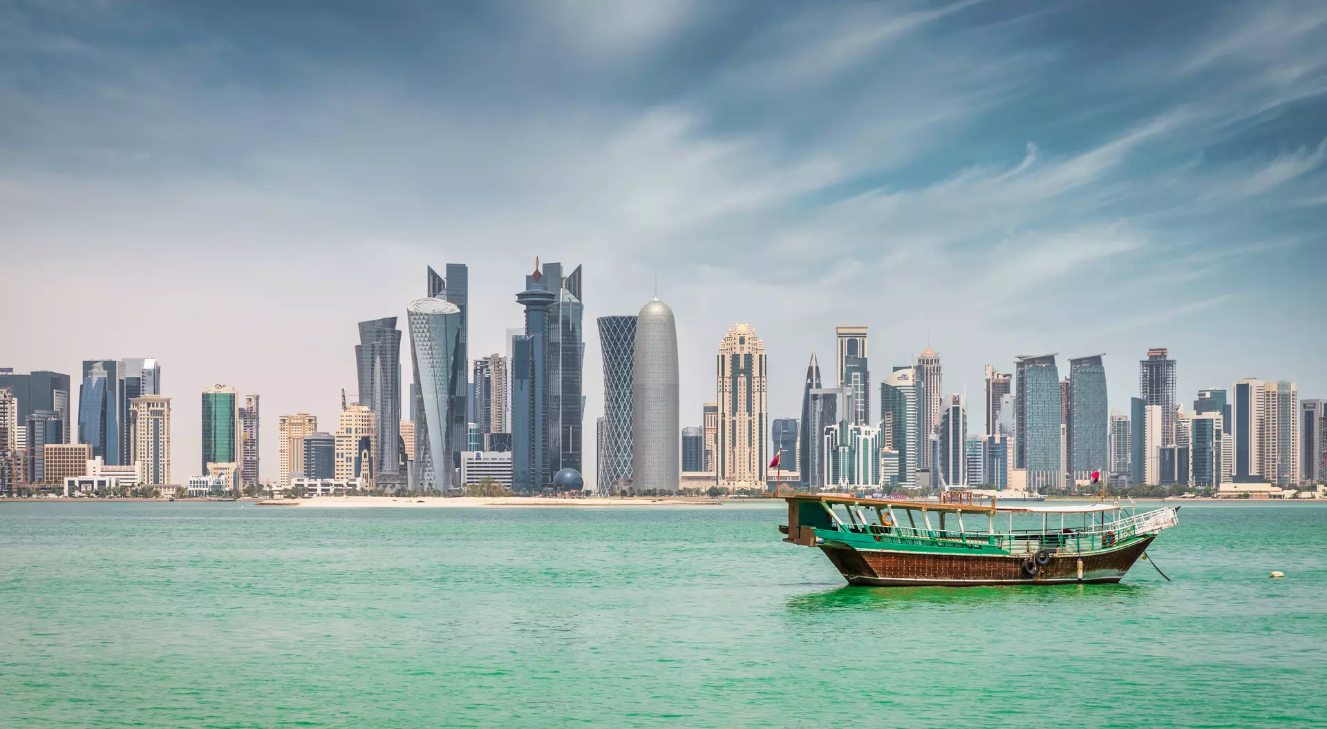Corniche Promenade Waterfront panorama at Doha Corniche Promenade with anchored typical qatari Dhow Cruise Boat