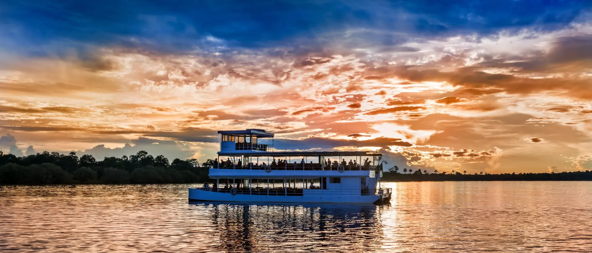 Picturesque sunset landscape with the riverboat at Zambezi river