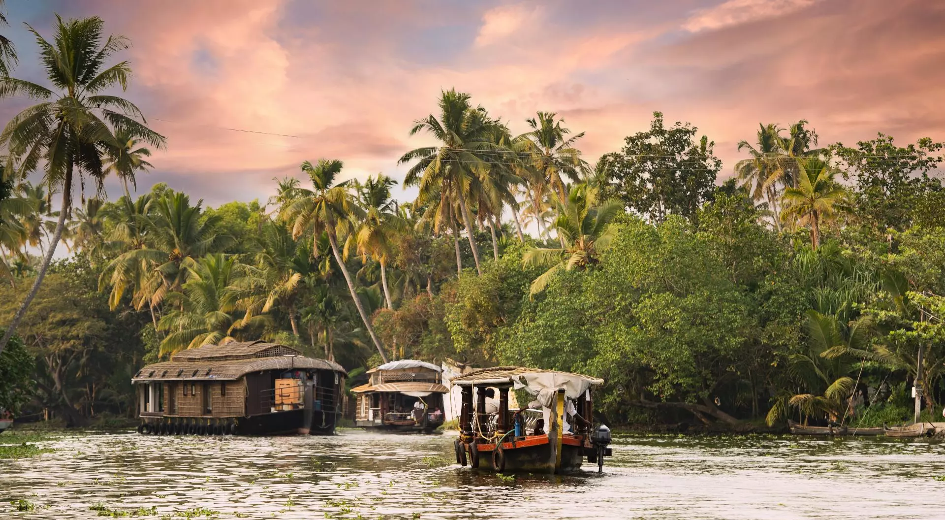 Kerala Backwaters Stunning view of a house boat sailing on the Alleppey's backwaters during a beautiful sunset