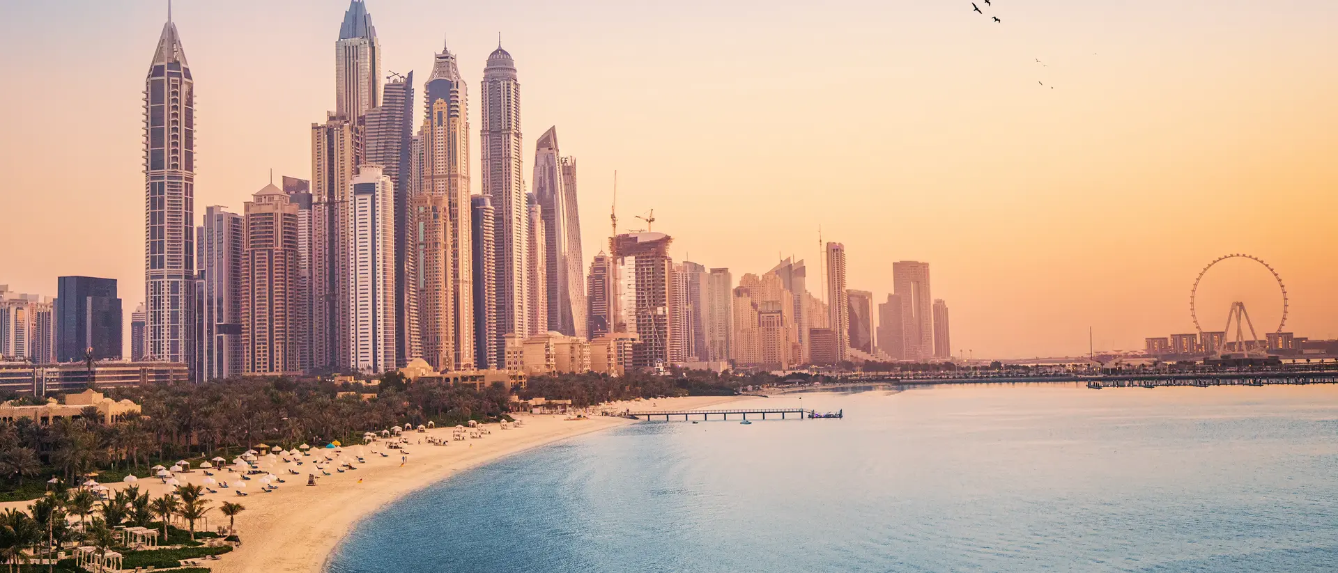 The Dubai Marina at sunset Sunset view of the Dubai Marina and JBR area and the famous Ferris Wheel and golden sand beaches in the Persian Gulf.