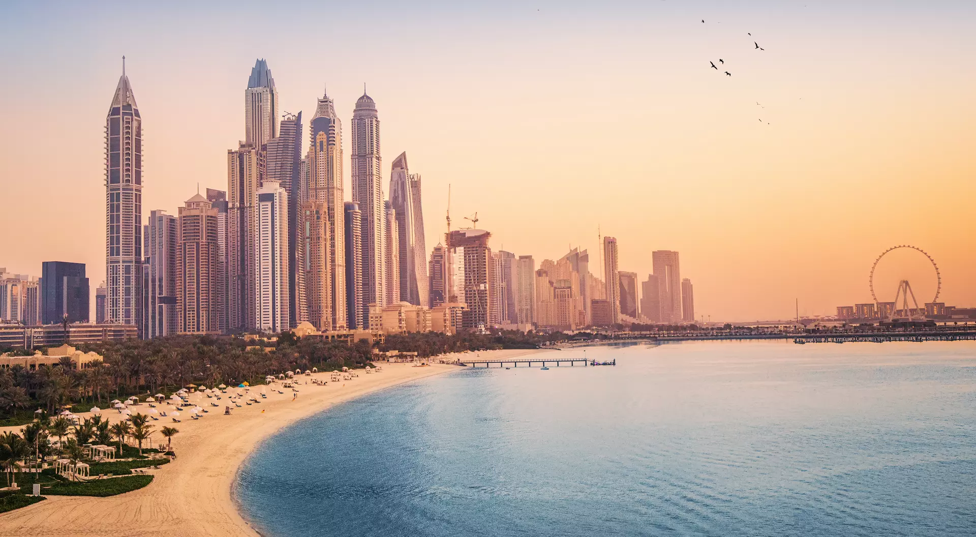 The Dubai Marina at sunset Sunset view of the Dubai Marina and JBR area and the famous Ferris Wheel and golden sand beaches in the Persian Gulf.