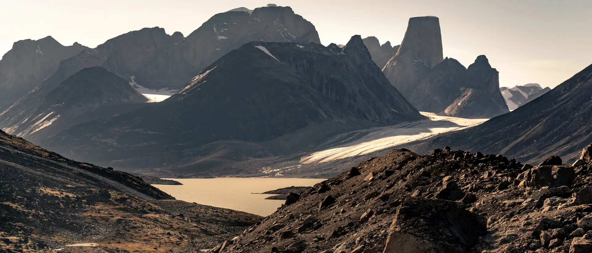 "Iconic granite rock of Mt.Asgard towers above Turner glacier in late summer afternoon light. Remote arctic valley of Akshayuk pass, Baffin Island, Canada "