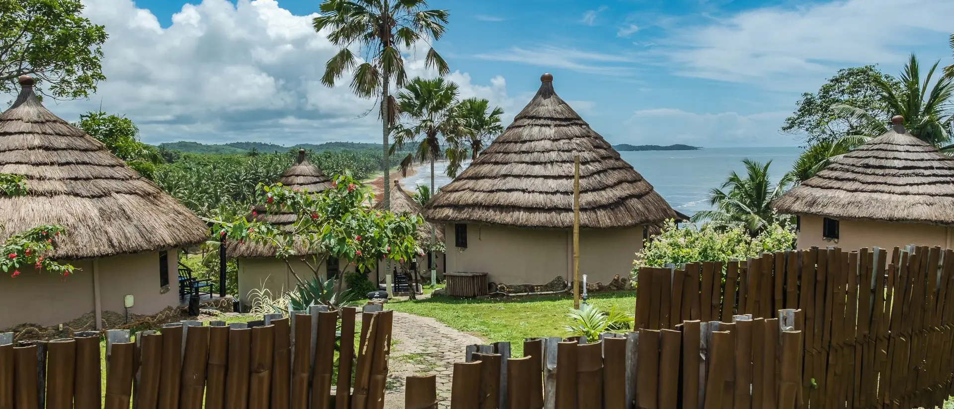 African bungalow with thatched roof and built in old tradition on a hill in Axim overlooking the sea located in Ghana West Africa