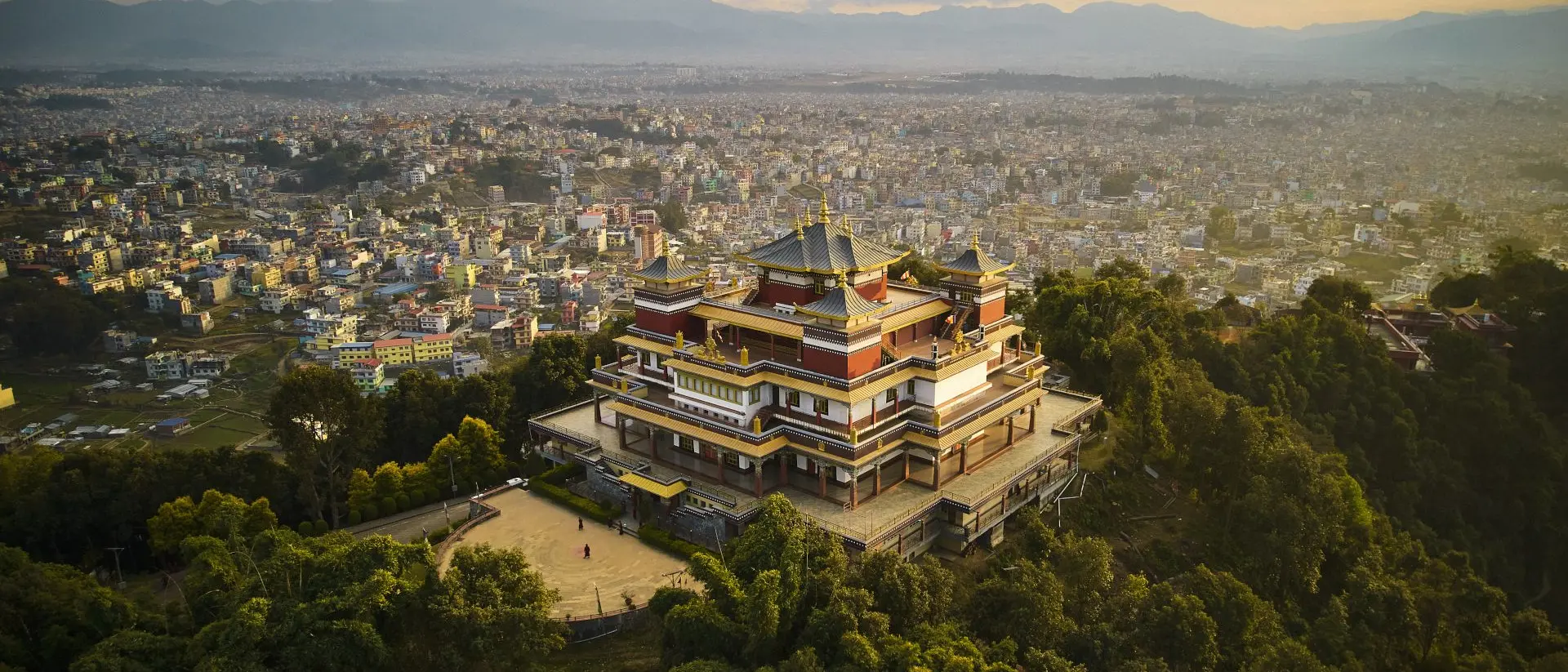 "Pullahari Monastery, Buddhist pilgrimage site on northern hill in Kathmandu Valley with city and mountains in background. "