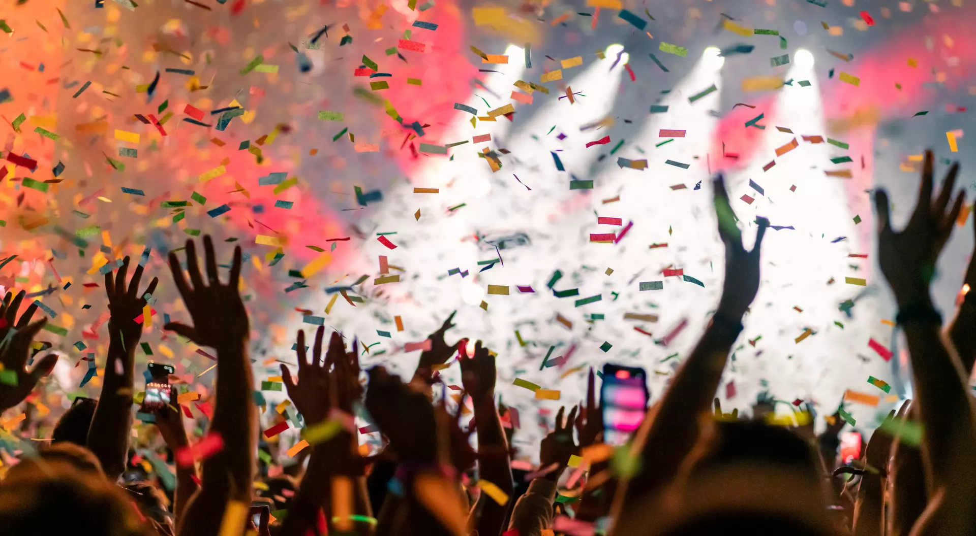 Music festival crowd with falling confetti.