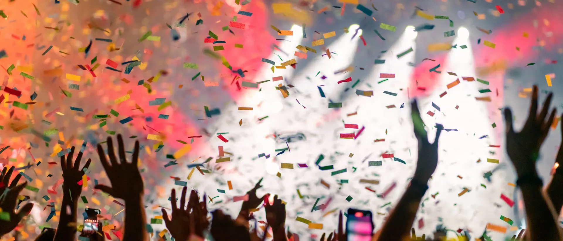 Music festival crowd with falling confetti.
