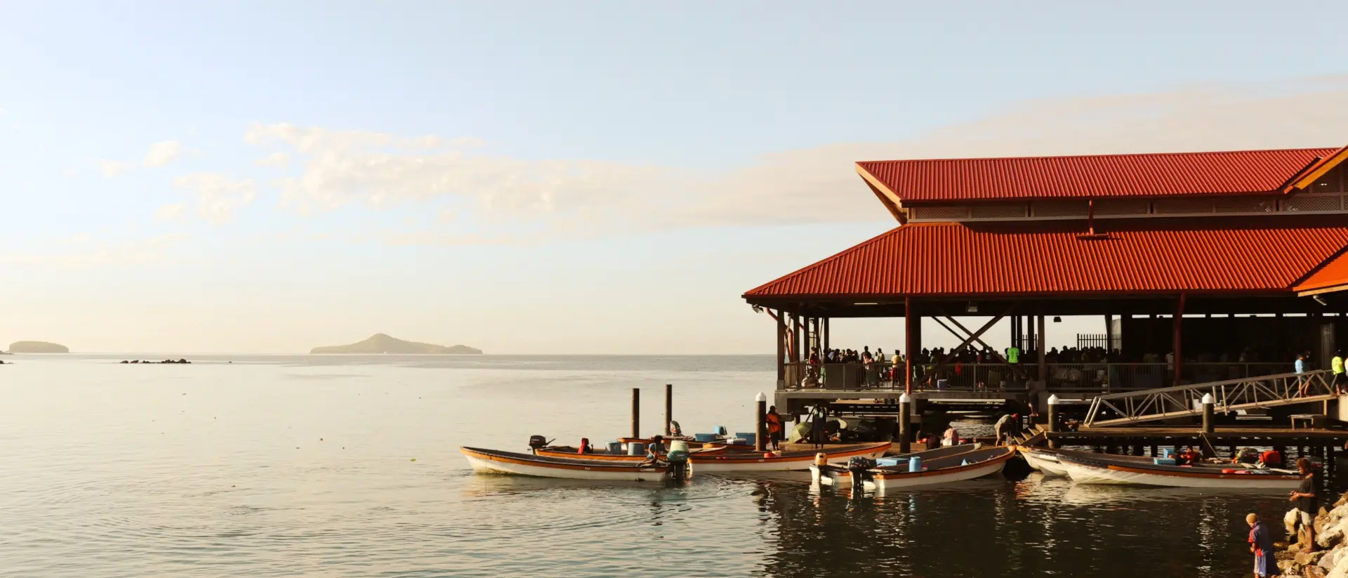 Boats on dock beside oceanside Papua New Guinea market