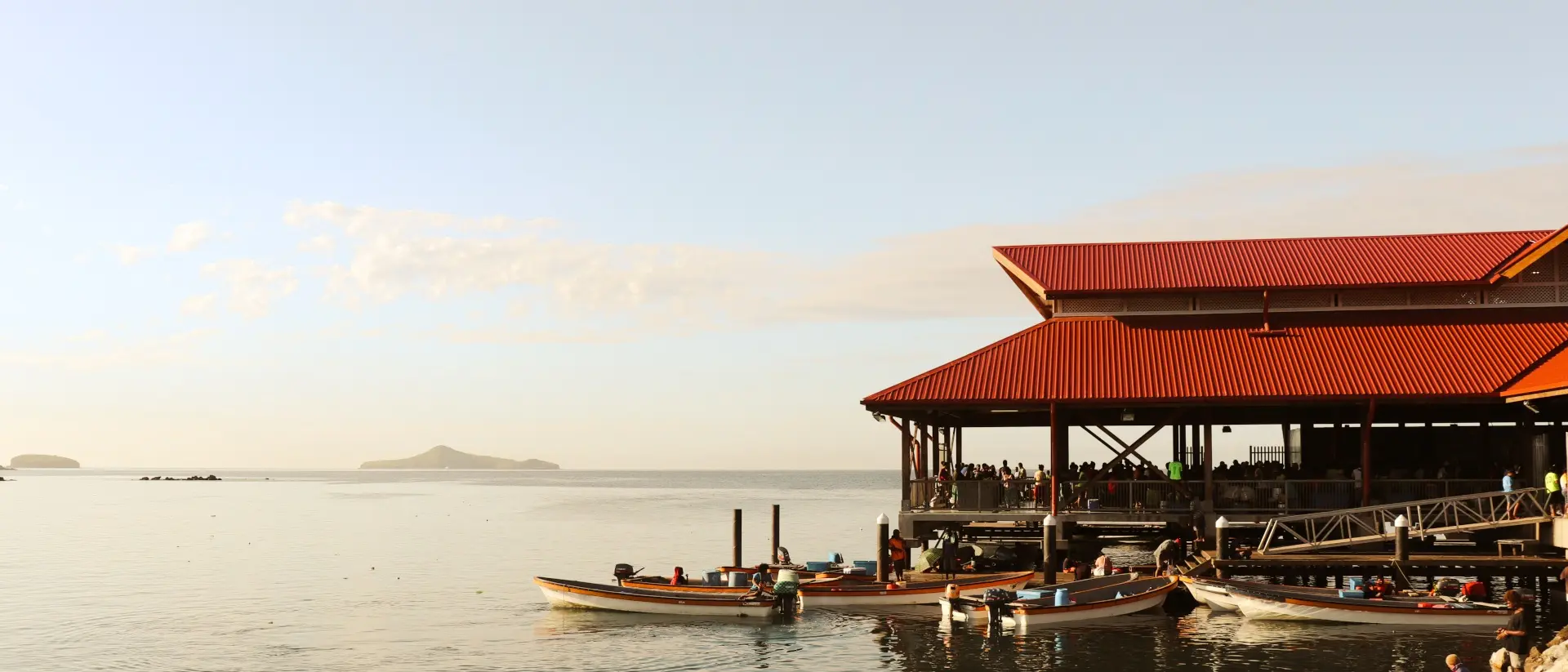 Boats on dock beside oceanside Papua New Guinea market
