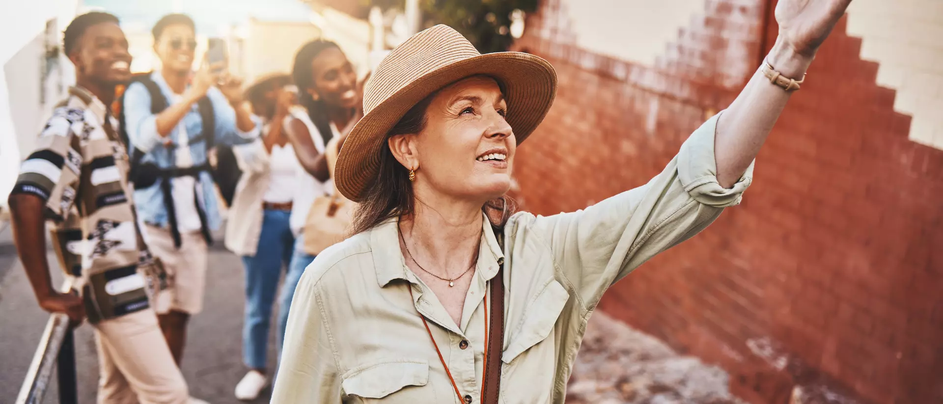 Woman, city guide and group of happy tourists, pointing at local architecture