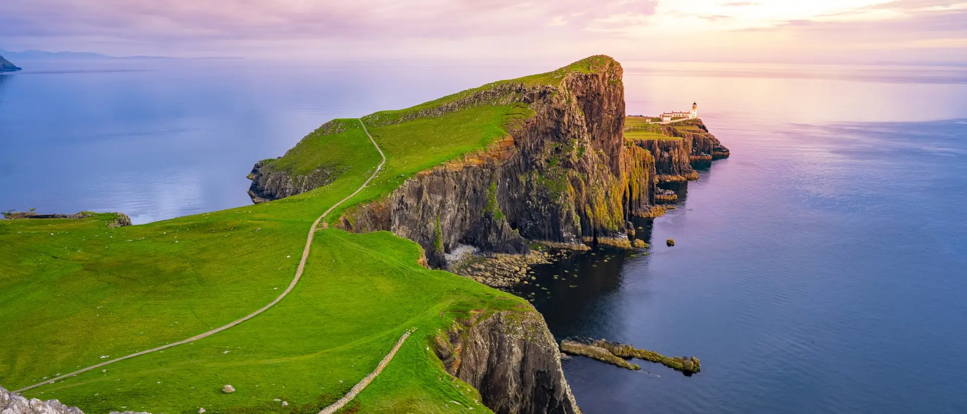 Neist Point Lighthouse, Isle of Skye Lightouse at edge of cliff overlooking atlantic ocean
