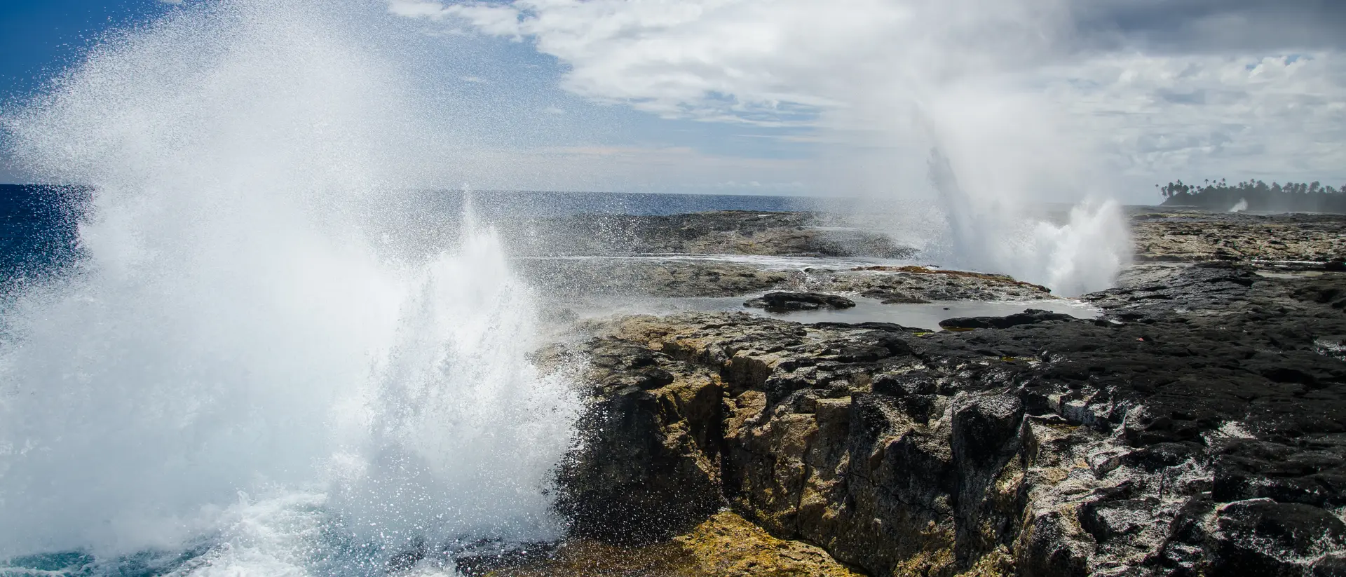 Alofaaga Blowholes The Alofaaga Blowholes send water towards the bright blue sky along the ocean in Somoa