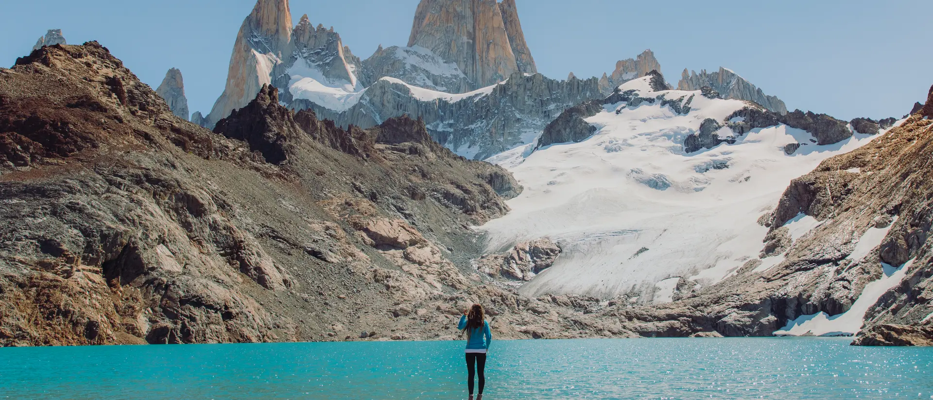 Mount Fitz Roy, Patagonia Female explorer hiking to the turquoise glacial lagoon with view of Mount Fitz Roy in El Chalten, Argentina
