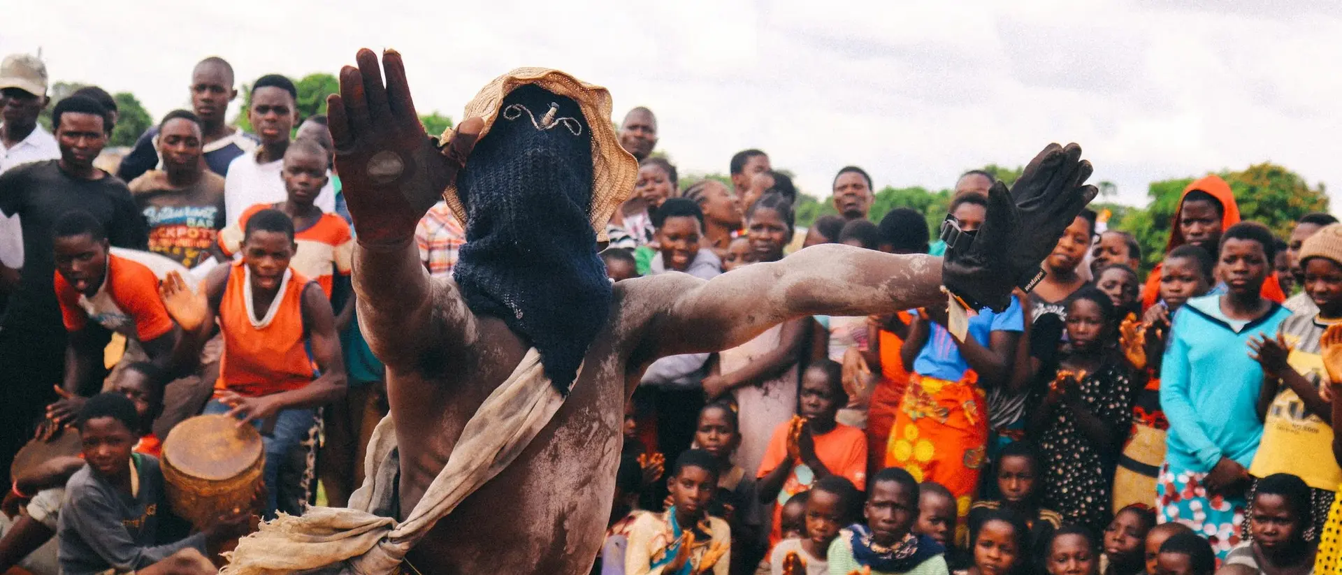 A dancer in traditional attire performs in front of a captivated crowd, showcasing vibrant cultural celebration.
