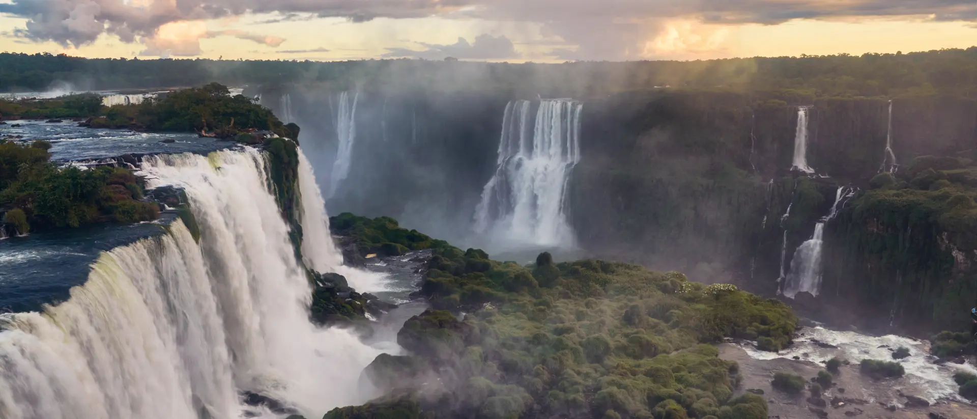 Breathtaking view of the Iguazu Falls gleaming under the cloudy sky in South America