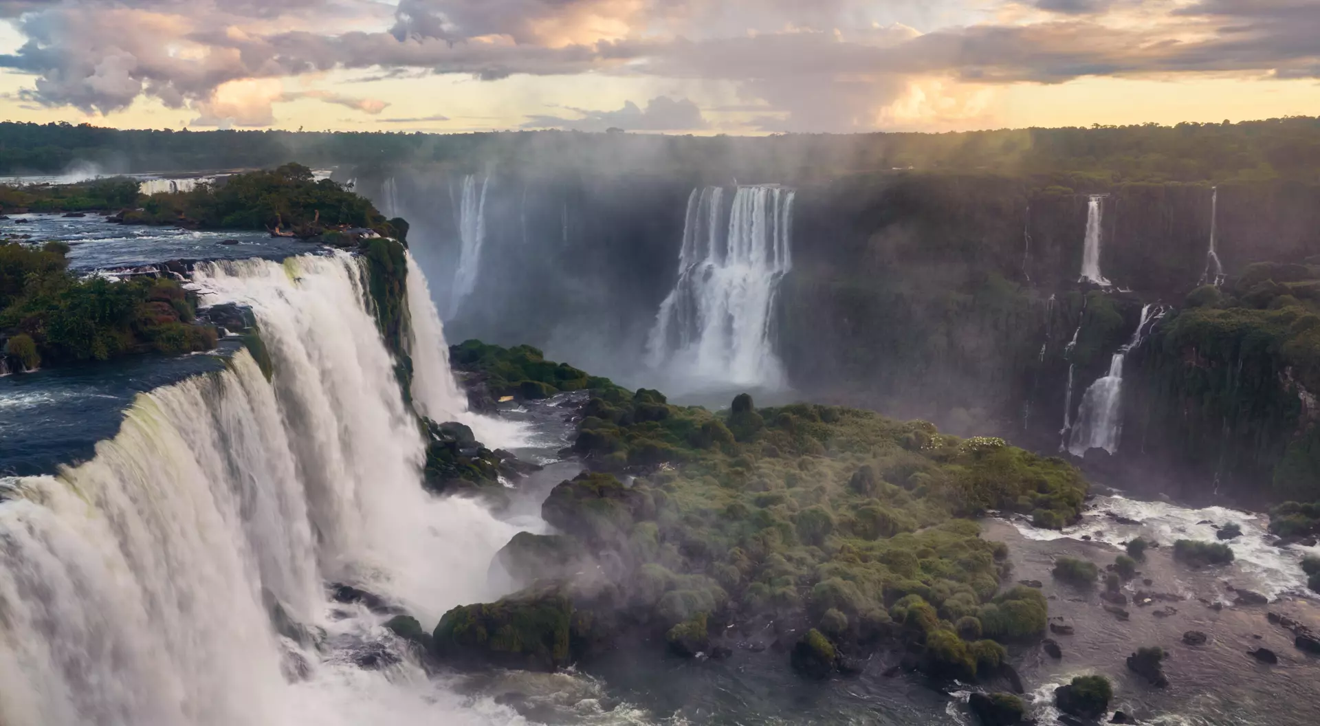 Breathtaking view of the Iguazu Falls gleaming under the cloudy sky in South America