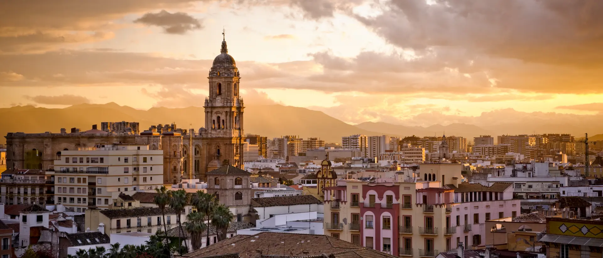 Malaga, Andalusia Sunset over city skyline and distant mountains