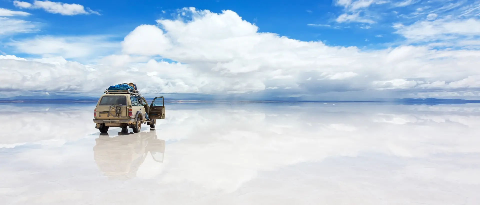 Salar de Uyuni The world's largest salt flat, Salar de Uyuni in Bolivia, with Jeep vehicle driving over